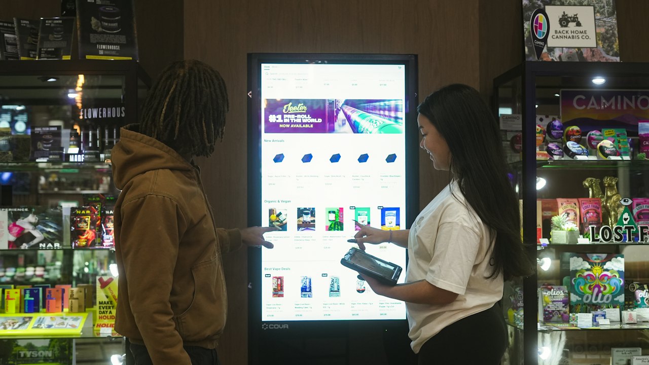 Two people using a large touchscreen display