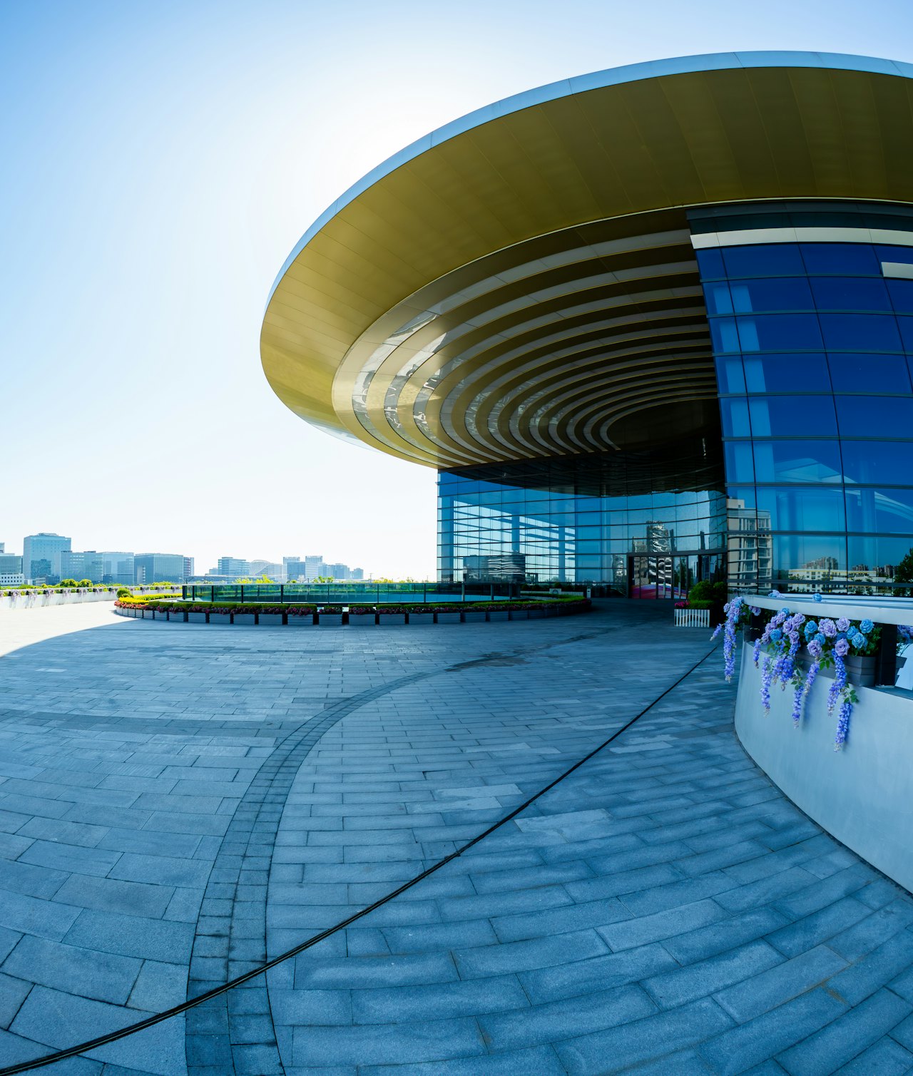 A modern building with a circular roof under a blue sky
